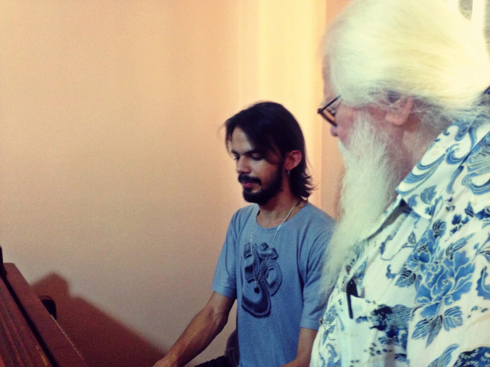 A young Salomão Soares at the piano, with Hermeto Pascoal standing beside him, listening