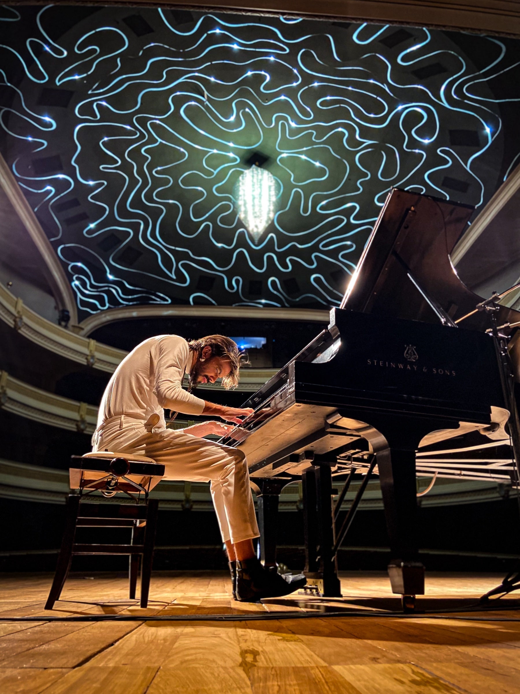 Salomão Soares at the piano on the stage of Theatro Pedro II, during the recording of Interior